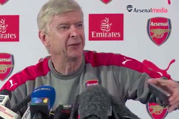 Arsene Wenger picks up a phone that rang during press conference