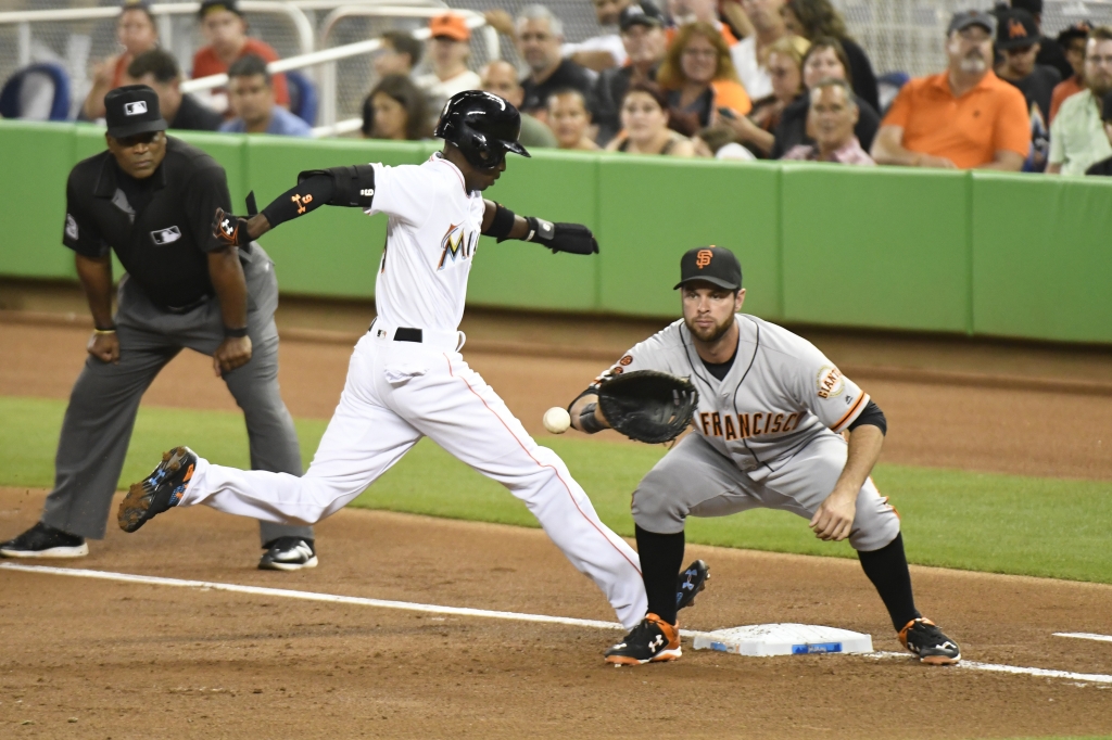 Dee Gordon #9 of the Miami Marlins runs back towards first base in the 1st inning after a pick off attempt by Johnny Cueto #47 of the San Francisco Giants at Marlins Park