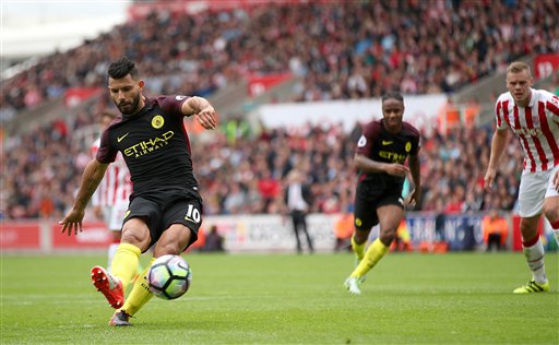 Manchester City's Sergio Aguero foreground scores his side's first goal of the match from the penalty spot during the English Premier League soccer match between Stoke City and Manchester City at The Bet365 Stadium in Stoke