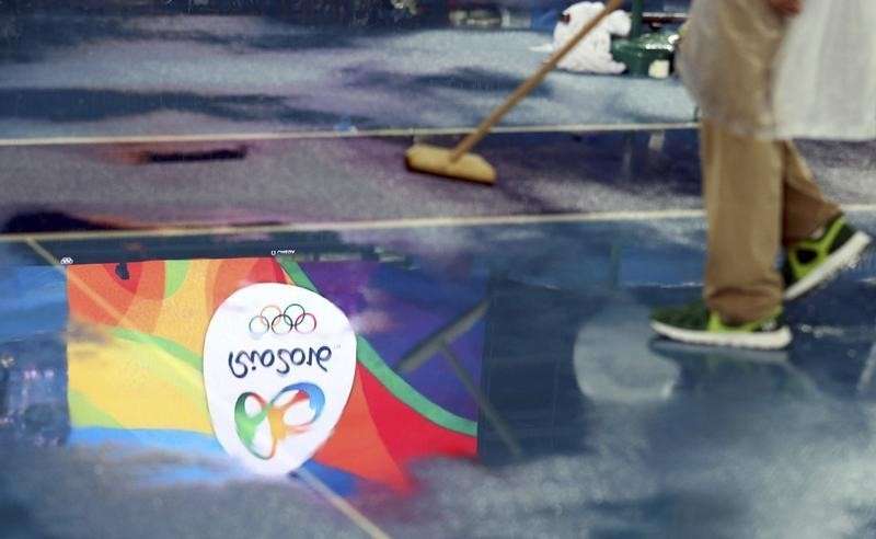 2016 Rio Olympics- Athletics- Final- Men's Pole Vault Final- Olympic Stadium- Rio de Janeiro Brazil- 15/08/2016. The Olympics logo is reflected on the track as rainwater is cleared away. REUTERS  Phil Noble