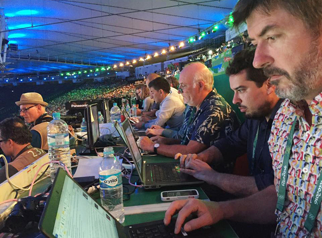 Associated Press writers John Leicester right and Mauricio Savarese second from right work at the press table in the Maracana