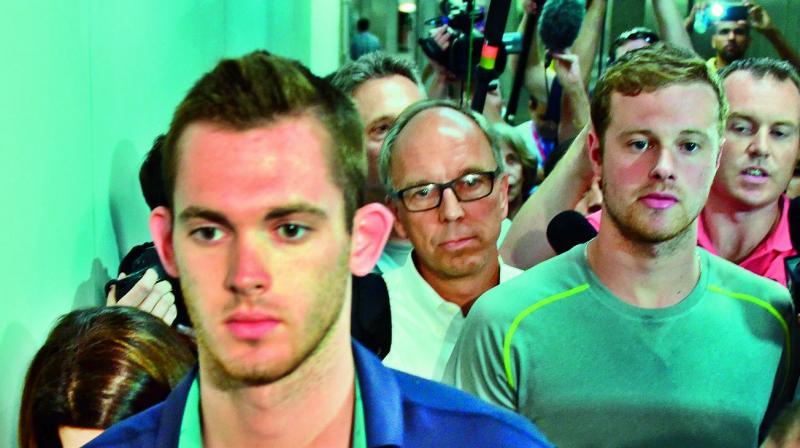 American swimmers Gunnar Bentz and Jack Conger leave the police station at the Rio de Janeiro International Airport after being detained on the plane that flew back to the US