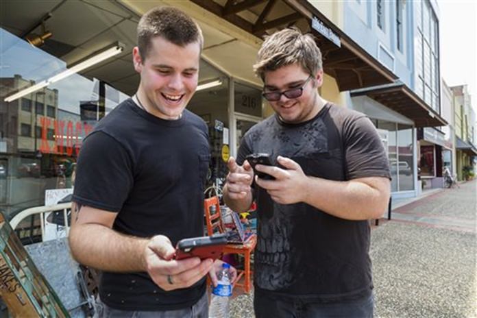 Brothers Jon and Ryan Edmonds play the augmented-reality smartphone game Pok้mon Go in downtown Texarkana Arkansas