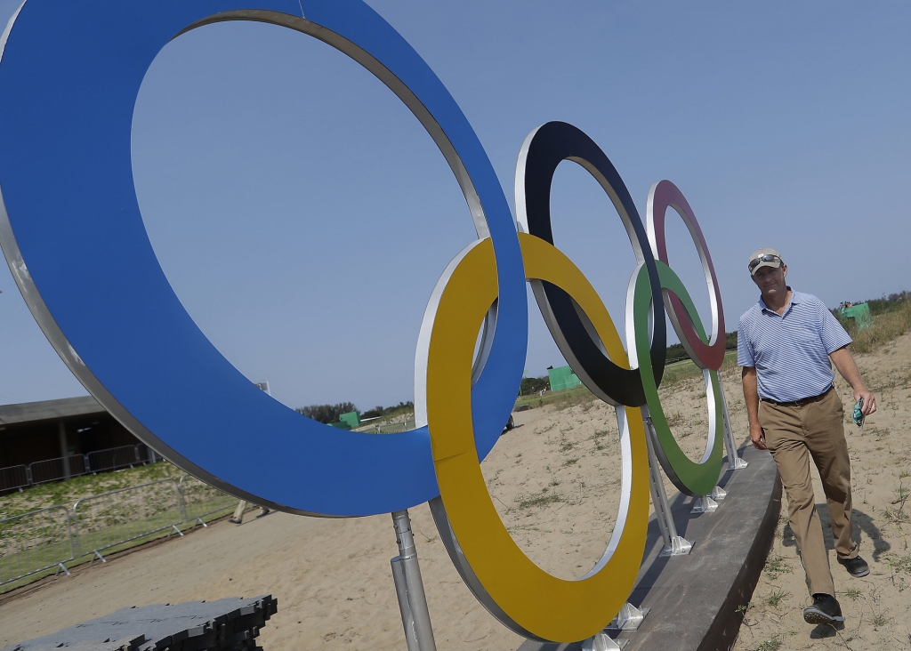 Designer of the Olympic golf course Gil Hanse walks past a set of olympic rings near the first tee on the course for the 2016 Summer Olympics in Rio de Janeiro Brazil Tuesday Aug. 9 2016