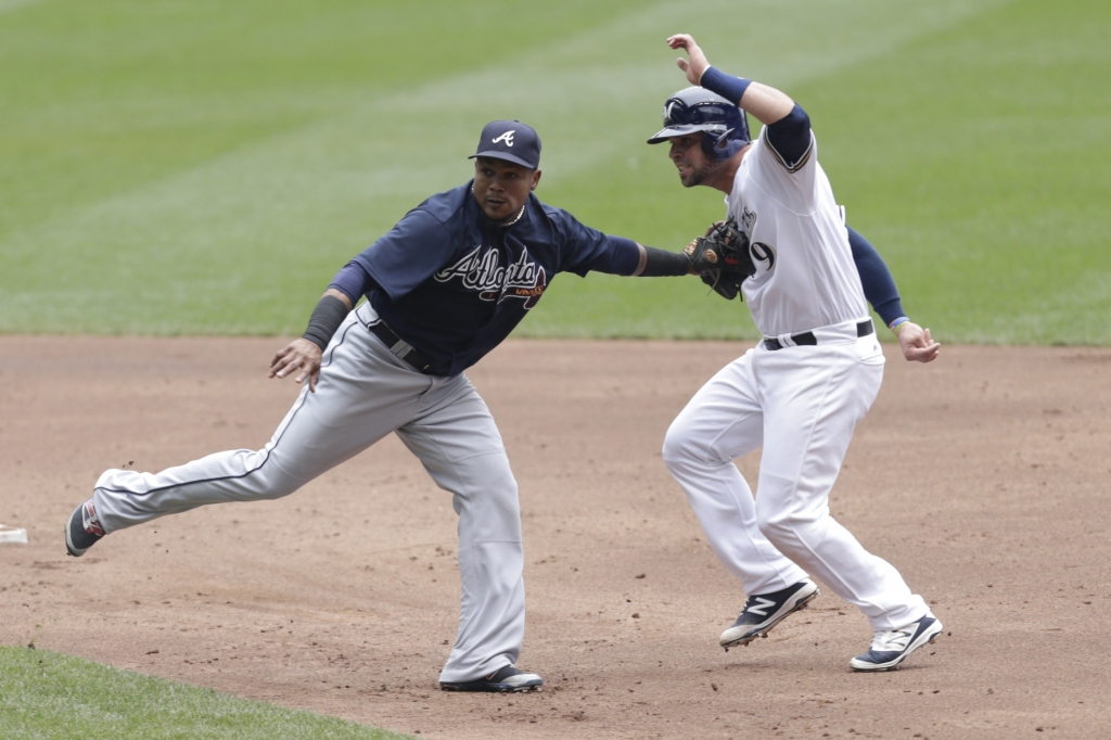 MILWAUKEE WI- AUGUST 11 Erick Aybar #1 of the Atlanta Braves tags out Manny Pina #9 of the Milwaukee Brewers in a run down during the second inning against the Milwaukee Brewers at Miller Park