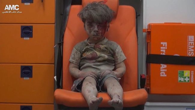 In this frame grab taken from video provided by the Syrian anti-government activist group Aleppo Media Center, 5-year-old Omran Daqneesh sits in an ambulance after being pulled out or a building hit by an airstirke in Aleppo Syria Wednesday Aug