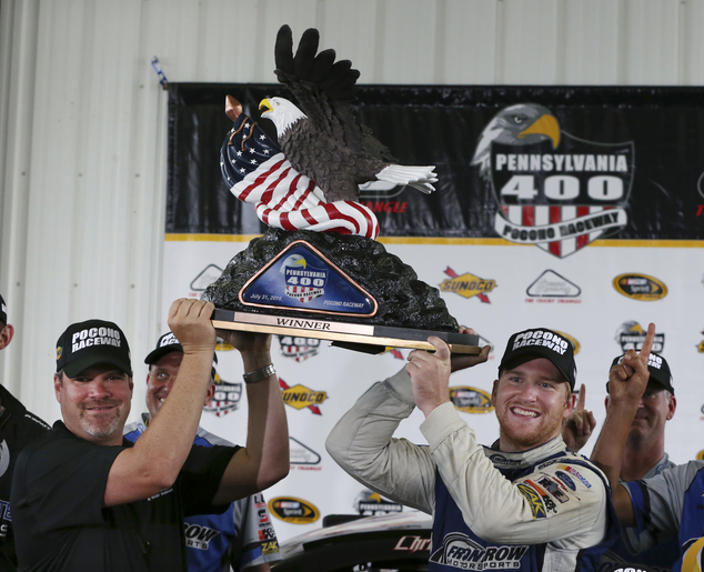 Chris Buescher right  holds up the winner's trophy with the help of President of Pocono Raceway Brandon Igdalsky after winning the NASCAR Sprint Cup Se