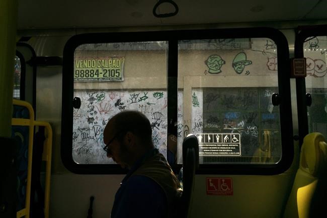 A journalist sits in a shuttle bus en route to the Whitewater Stadium a venue for the canoe and kayak slalom events at the 2016 Summer Olympics in Rio de Janeiro Brazil Tuesday Aug. 9 2016