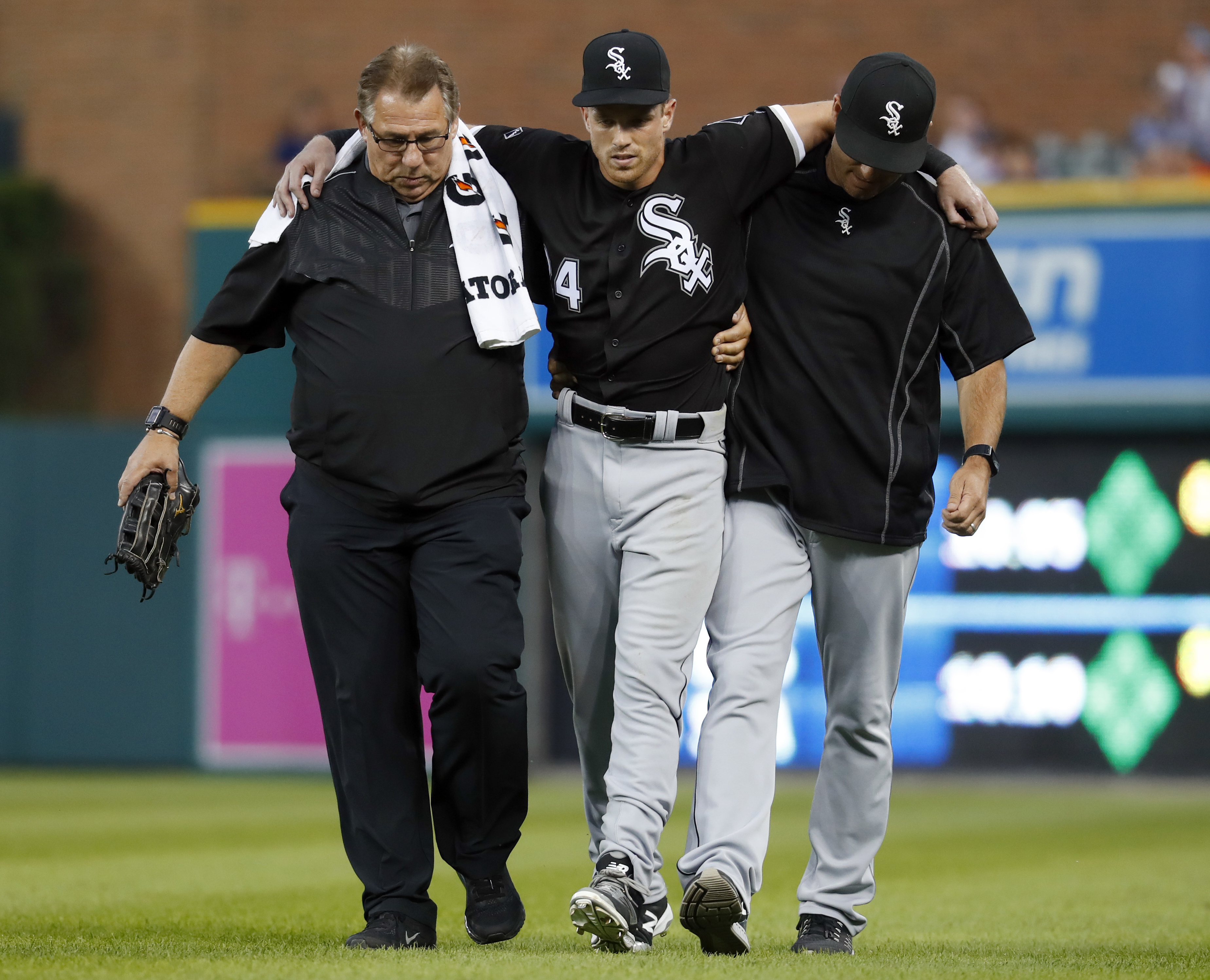 Chicago White Sox center fielder Charlie Tilson center is helped off the field by athletic trainer Herm Schneider left and manager Robin Ventura during the fifth inning of a baseball game against the Detroit Tigers Tuesday Aug. 2 2016 in Detroit