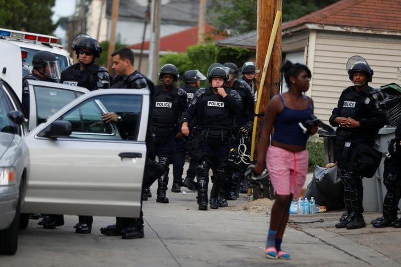 Police in riot gear assemble in an alley after disturbances following the police shooting of a man in Milwaukee Wisconsin