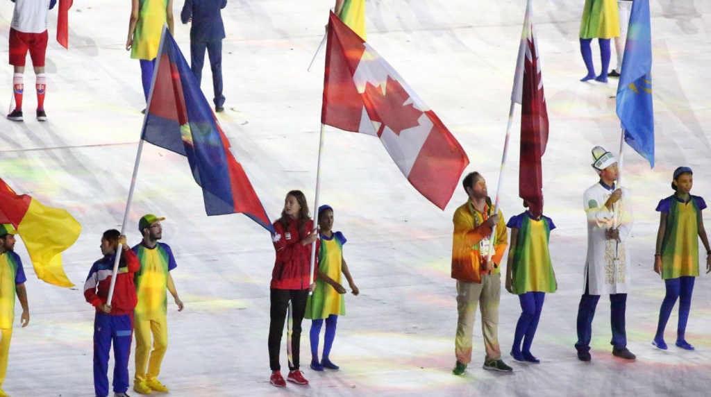 Canadian swimmer Penny Oleksiak bears the Canadian flag at the closing ceremony of Rio Olympics