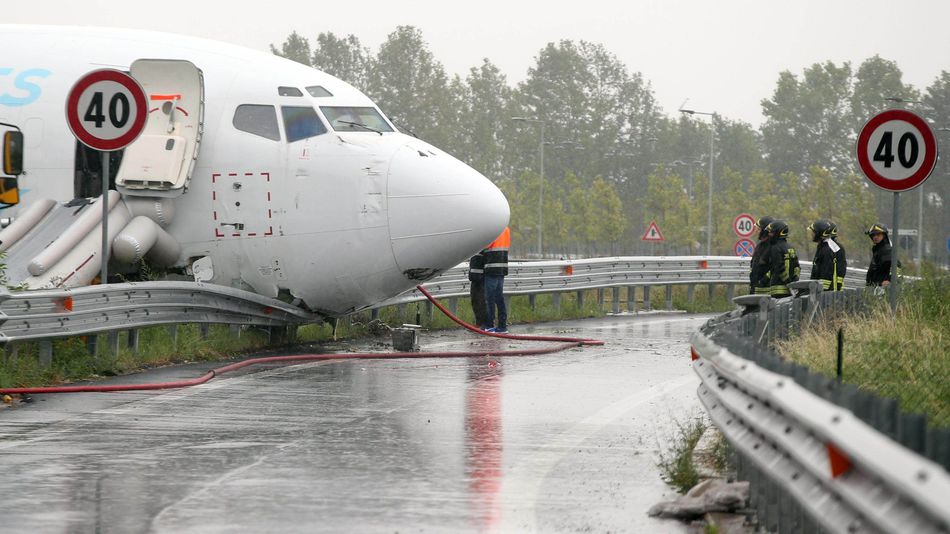 Firefighters work on DHL cargo plane that skidded off a runway at Orio al Serio airport overnight busting through a perimeter fence and onto a provincial highway near Bergamo in Northern Italy Friday Aug. 5 2016