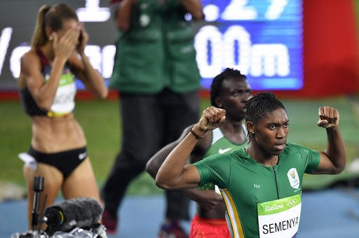 South Africa's Caster Semenya celebrates winning the gold medal in the women's 800-meter final as fourth placed Canada's Melissa Bishop covers her face during the athletics competitions of the 2016 Summer Olympics at the Olympic stadium in Rio de Janeiro