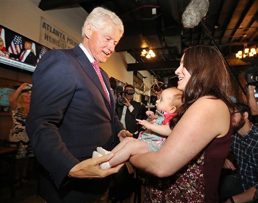 Former President Bill Clinton left says hello to Megan Bartlett of Decatur Ga. and her 3-month-old daughter Hannah Rice as he works the crowd at historic Manuel's Tavern Wednesday Aug. 24 2