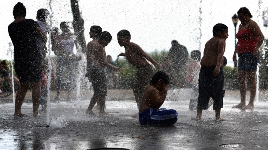 Children play in water jets of Battery Bosque Park fountain over the weekend during the heat wave