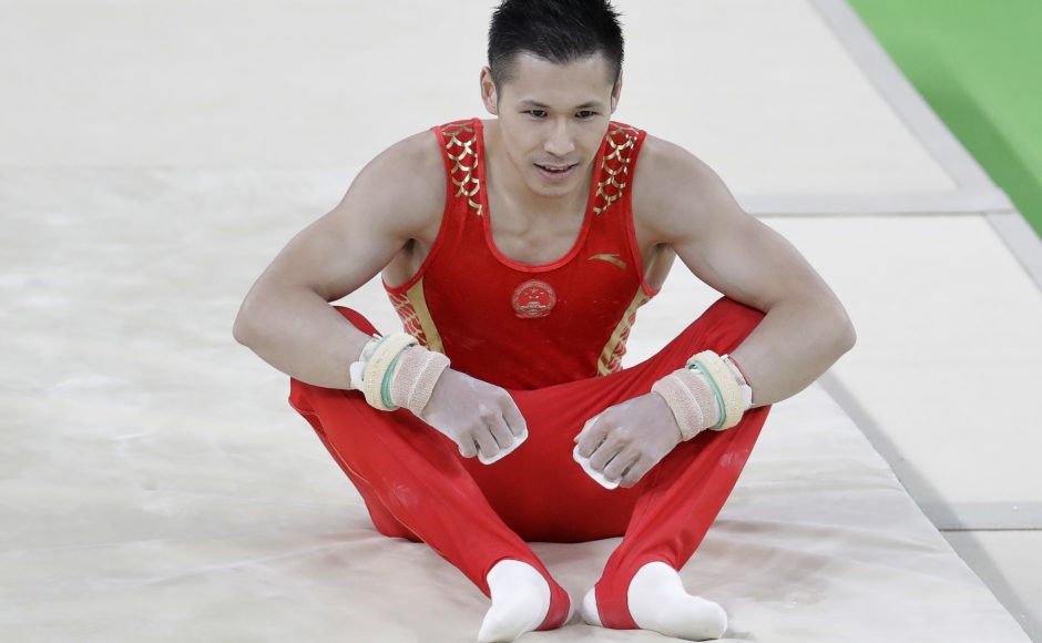 China's Zhang Chenglong sits on the floor after falling from the horizontal bar at the 2016 Summer Olympics in Rio. Pic AP