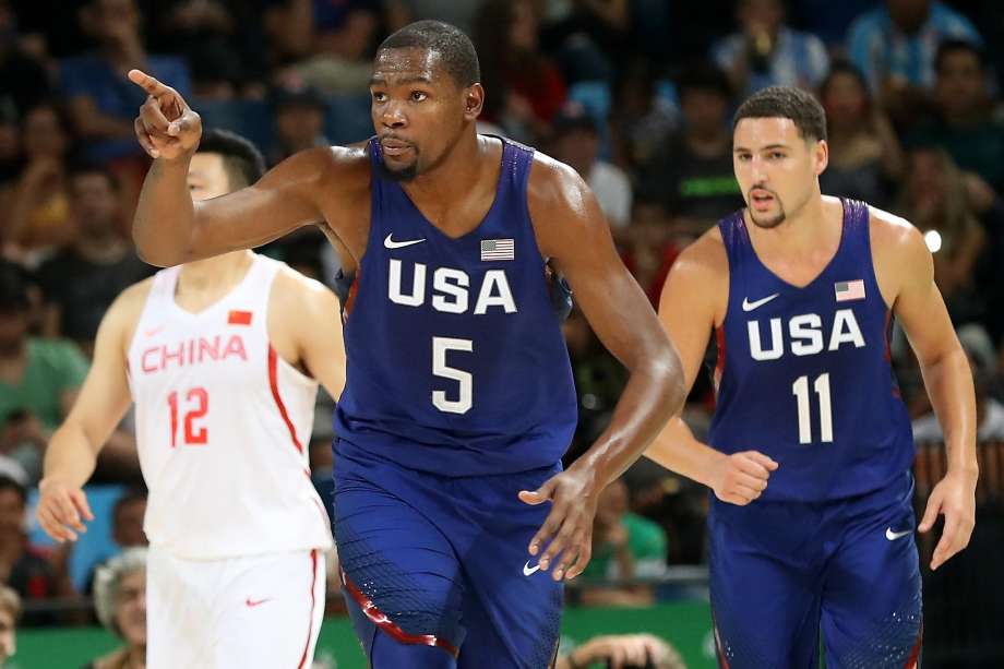 Kevin Durant celebrates a basket as in front of China’s Gen Li and Warriors teammate Klay Thompson in the 119-62