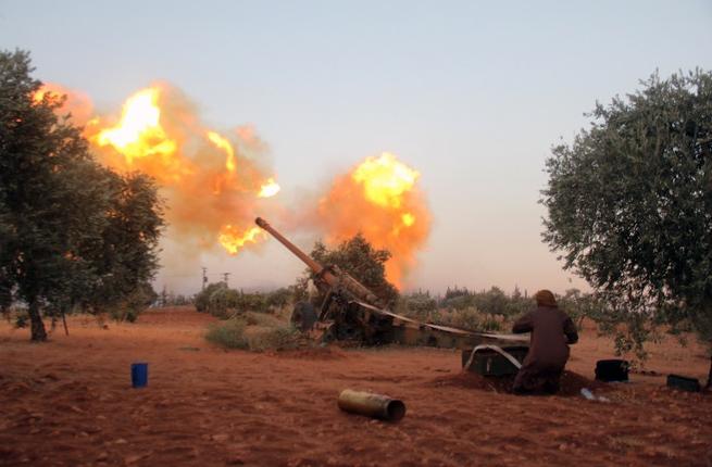 Opposition fighters belonging to Ajnad Al-Sham fire shells from their position in Aleppo's southern countryside towards regime positions