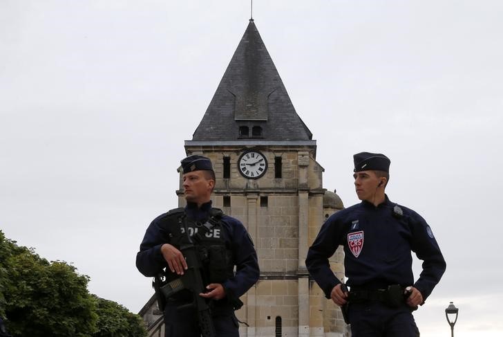 French CRS police stand guard in front of the church a day after a hostage taking in Saint Etienne du Rouvray near Rouen in Normandy France where French priest Father Jacques Hamel was killed with a knife and another hostage seriously wounded in an attack