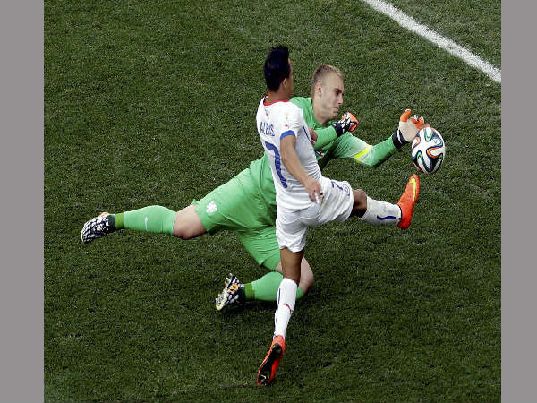 Chile's Alexis Sanchez is challenged by Netherlands goalkeeper Jasper Cillessen during the group B World Cup soccer match between the Netherlands and Chile at the Itaquerao Stadium in Sao Paulo Brazil