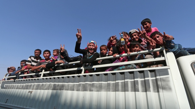 Civilians react as they prepare to leave Manbij on Friday