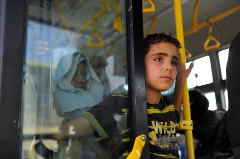 Civilians ride a bus to be evacuated from the besieged Damascus suburb of Darayya on Aug. 26