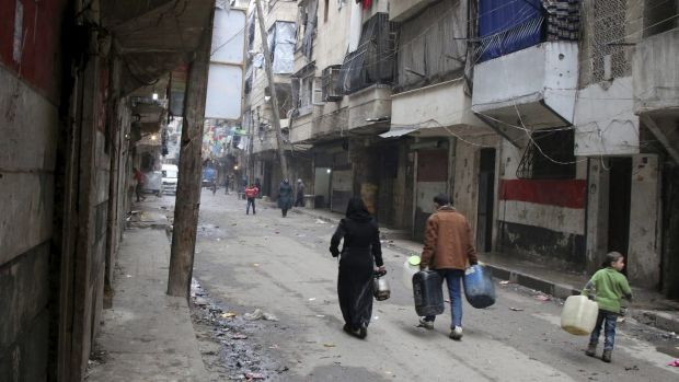 Civilians walk with containers for fuel and water in Aleppo Syria in this