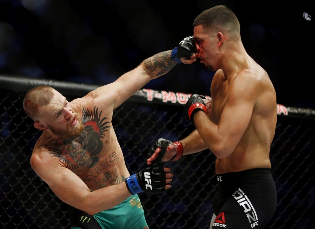 Conor McGregor left connects with a punch to Nate Diaz during their welterweight MMA bout at UFC 202 Saturday. Isaac Brekken the associated press