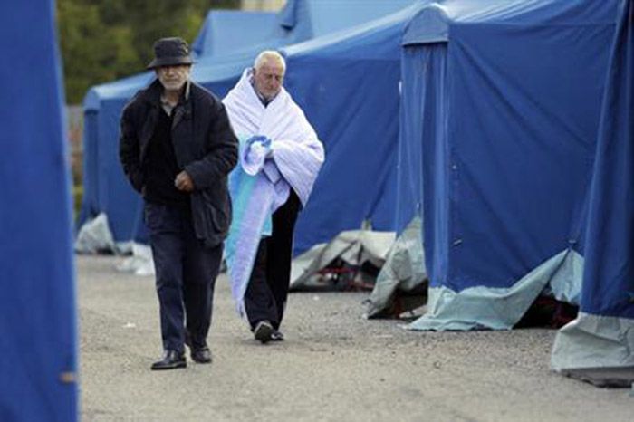 People walk in a tent camp near Pescara Del Tronto Italy Thursday Aug. 25 2016