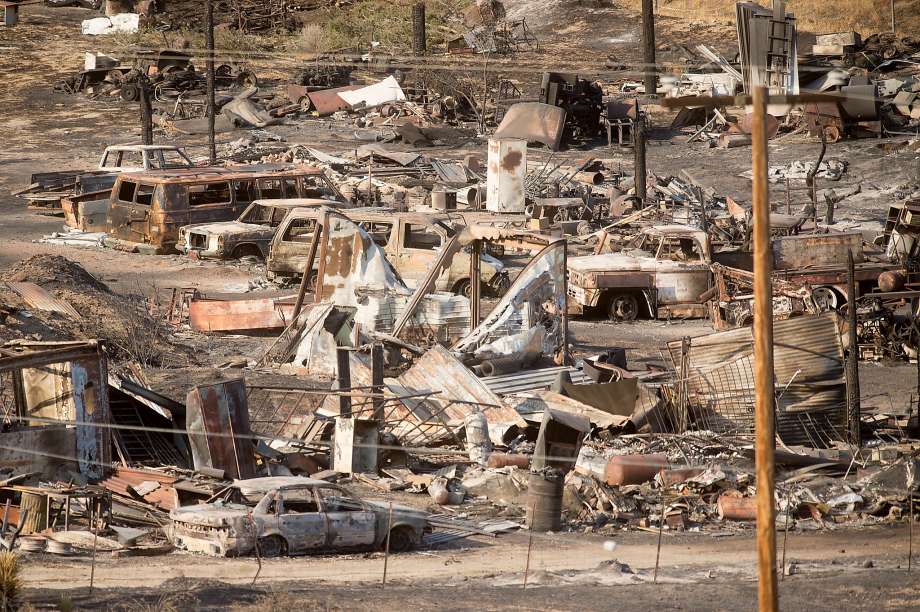 Scorched cars and trailers destroyed by the Blue Cut fire line a street in Phelan. The fire was 68 percent contained Saturday