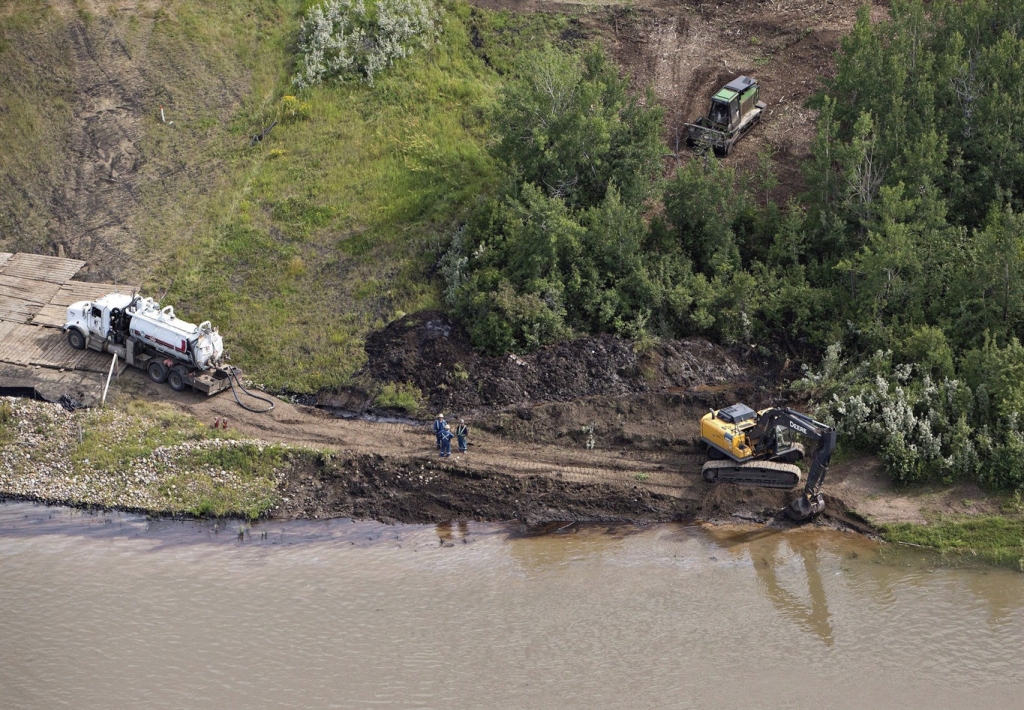 Crews work to clean up an oil spill on the North Saskatchewan river near Maidstone Sask on Friday