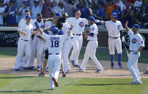 Chicago Cubs&#039 Ben Zobrist joins his teammates as they celebrate the team's 5-4 win over the Miami Marlins after Marlins&#039 relief pitcher A.J. Ramos threw a game winning wild pitch to Willson Contreras scoring Matt Szczur during the nin