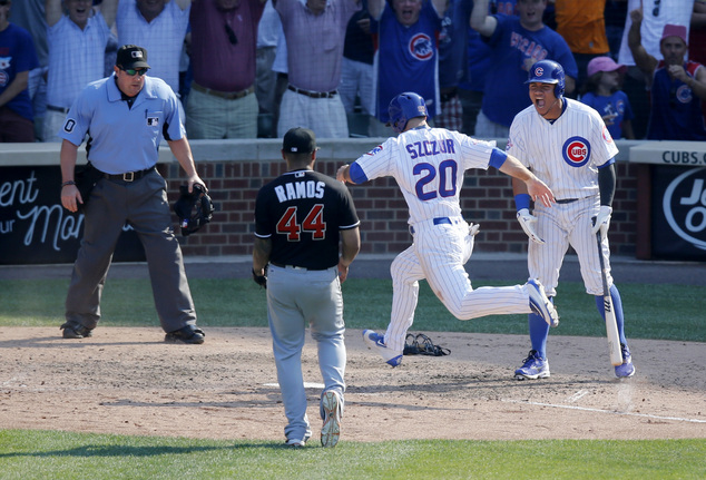 Chicago Cubs Matt Szczur scores the winning run on a wild pitch from Miami Marlins relief pitcher A.J. Ramos as Willson Contreras and umpire Marty