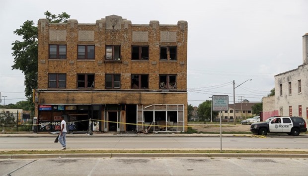 A burned down liquor store is seen after disturbances following the police shooting of a man in Milw