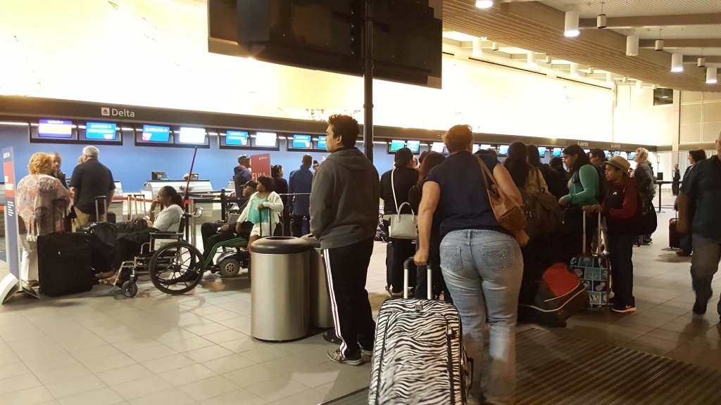 Customers stand in line at Sacramento International Airport after a Delta shortage grounded departing flights