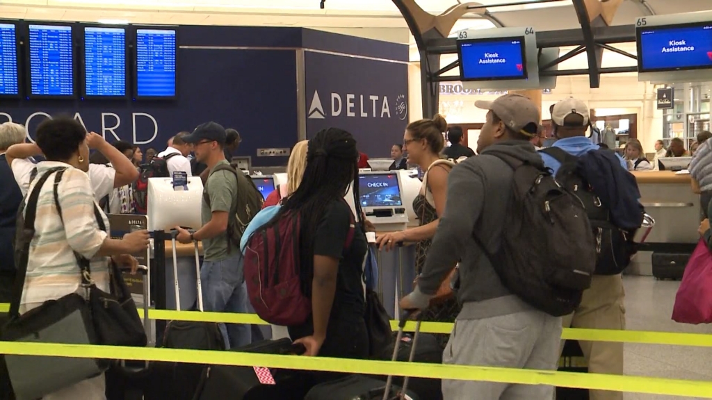 Customers wait in line at Hartsfield Jackson Atlanta International Airport after a Delta Air Lines computer outage grounded flights Monday morning