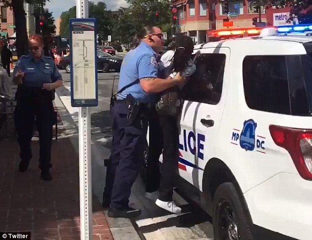 Grabbed Footage from Twitter shows a small black Washington DC woman identified only as'Shadon being held up roughly against a police cruiser by her arms