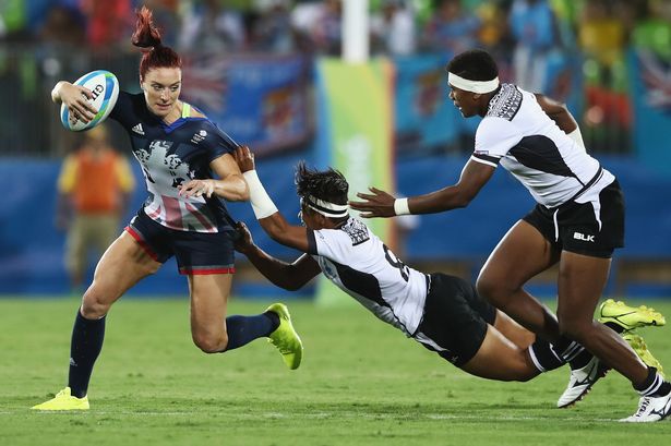 RIO DE JANEIRO BRAZIL- AUGUST 07 Joanne Watmore of Great Britain carries the ball under pressure from Lavenia Tinai of Fiji during the Women's Quarterfinal rugby match on Day 2 of the Rio 2016 Olympic Games at Deodoro Stadium