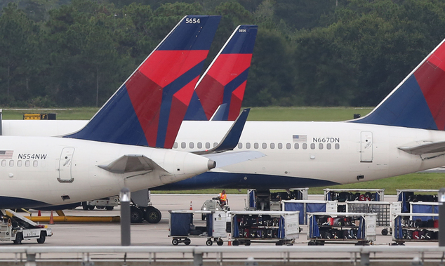 Luggage sits on the tarmac Monday Aug. 8 2016 by gates at Orlando International Airport in Orlando Fla. after a computer outage. Delta Air Lines delaye