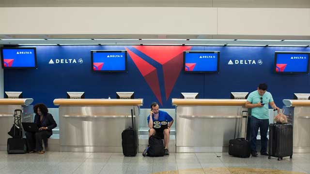 Passengers wait at Hartsfield–Jackson Atlanta International Airport Monday Aug. 8 2016 in Atlanta. Delta Air Lines delayed or canceled hundreds of flights Monday after its computer systems crashed stranding thousands