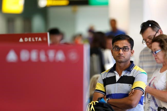 Delta passengers wait in line at a ticket counter at Newark Liberty International Airport in Newark N.J. Monday Aug. 8 2016. Delta Air Lines delayed or canceled hundreds of flights Monday after its computer systems crashed stranding thousands of peop