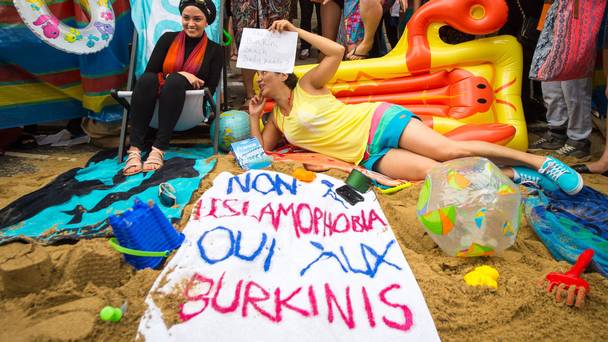 Demonstrators stage a beach party outside the French embassy in London in protest at the burkini ban in France