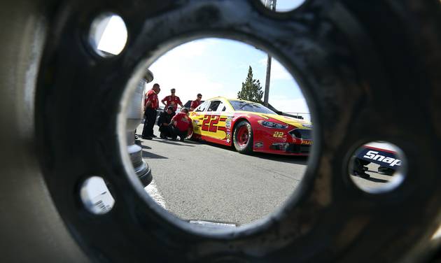 The race car of Joey Logano is seen through a race wheel in the garage area at Watkins Glen International racetrack during practice for Sunday's NASCAR Sprint Cup Series auto race Friday Aug. 5 2016 in Watkins Glen N.Y