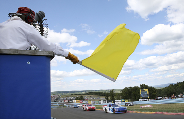 A track marshall waves a yellow caution flag during an NASCAR Xfinity series auto race at Watkins Glen International Saturday Aug. 6 2016 in Watkins Glen