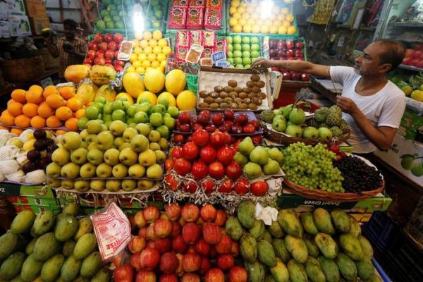 A vendor holds burning incense as he prays inside his fruit shop at a market in Kolkata India