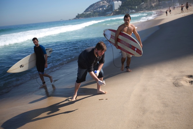 Doctoral candidate Rodrigo Staggemeier collects samples of sand from Ipanema beach for a study commissioned by The Associated Press