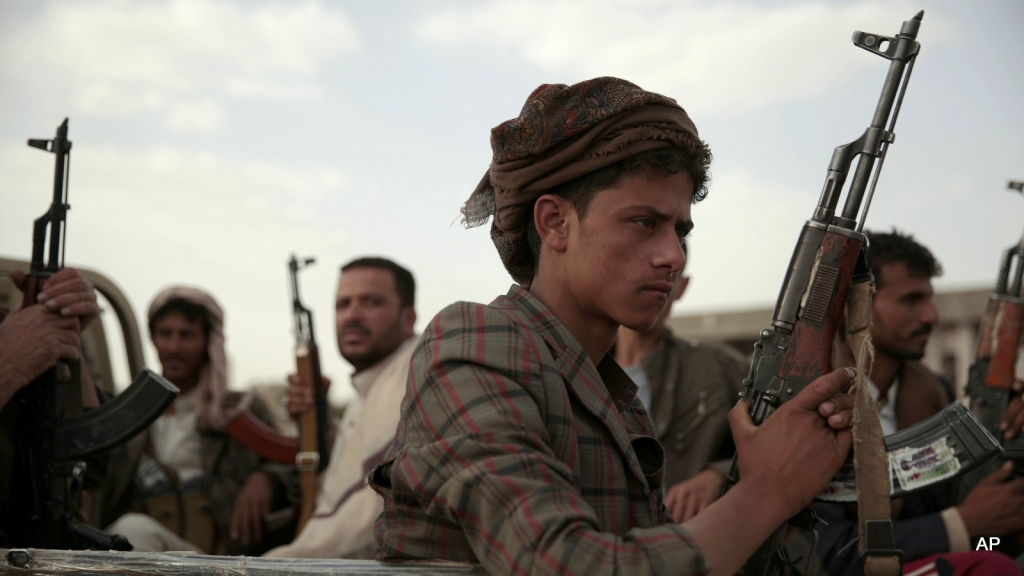 Houthi rebels ride on a pickup truck as they attend a gathering aimed at mobilizing more fighters into battlefronts in several Yemeni cities in Sanaa