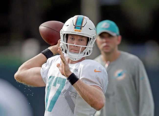 Miami Dolphins quarterback Ryan Tannehill prepares to throw a pass as assistant coach Bo Hardegree right watches during practice at the NFL football teams training camp Tuesday Aug. 9 2016 in Davie Fla