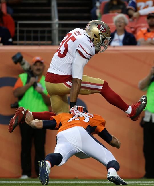 San Francisco 49ers free safety Eric Reid leaps over Denver Broncos quarterback Trevor Siemian as Reid runs for a touchdown after intercepting a pass from Siemian during the first half of a preseason NFL football game Saturday Aug. 20 2016 in Denver