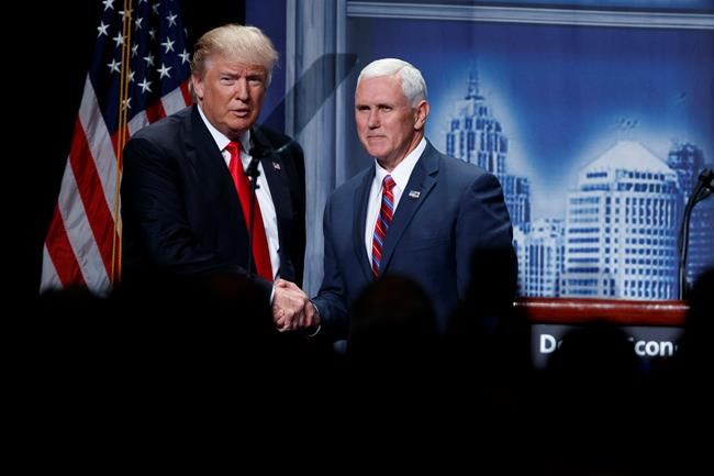 Republican presidential candidate Donald Trump shakes hands with his running mate Republican vice presidential candidate Indiana Gov. Mike Pence as he arrives to give an economic policy speech to the Detroit Econo